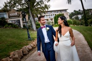 a bride and groom walking down a pathway with hotel in the background at castillo hotel son vida destination wedding by sean leblanc